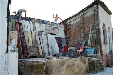 サンティアゴ・デ・キューバでハリケーンの被害にあった家を修理する男性。カメラを向けると手を振ってきた＝キューバ（緑川真実さん撮影）