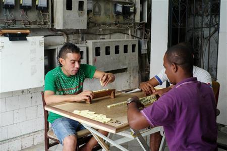 首都ハバナの古びた建物のエントランスで麻雀風のゲームにこうじる若者＝キューバ（緑川真実さん撮影）