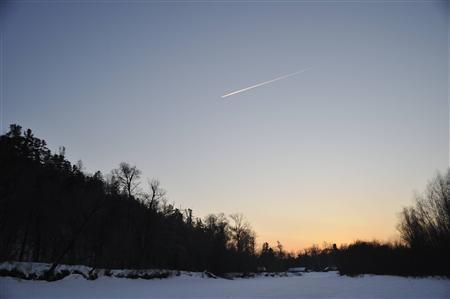 夕暮れのタイガの空を飛行機が飛んでいった。川辺の狩小屋での夕食が楽しみだ＝２０１１年２月２１日、ロシア・クラスヌイ・ヤール村（伊藤健次さん撮影）