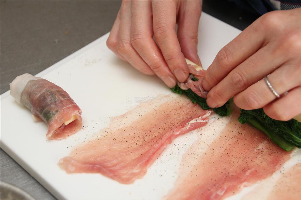 豚肉のチーズロール（作り方１）＿＿豚肉を広げ、塩・こしょうをふって、菜の花、チーズを並べ、端から巻く（今泉有美子撮影）