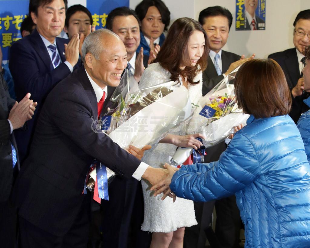 都知事選で初当選が決まり、支援者から花束を受け取る舛添（ますぞえ）要一氏。隣は雅美夫人＝２０１４年２月９日午後８時すぎ、東京都新宿区（松本健吾撮影）