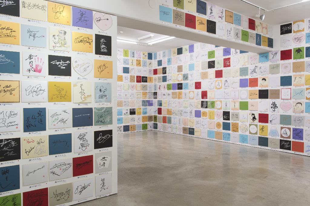 宇川直宏「ＵＫＡＷＡ’Ｓ＿ＴＡＧＳ＿ＦＡＣＴＯＲＹ！！！！！！！！！！（完結編）／１０００＿Ｃｏｕｎｔｅｒｆｅｉｔ＿Ａｕｔｏｇｒａｐｈ！！！！！！！！！！」の展示風景。時代やジャンル、著名度もさまざまな模写サインが並ぶ（三嶋一路さん撮影）。Ｃｏｕｒｔｅｓｙ＿ｏｆ＿ＹＡＭＡＭＯＴＯ＿ＧＥＮＤＡＩ