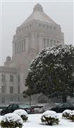 中央塔屋にも雪が積もりだした国会議事堂＝１４日午後、東京・永田町（酒巻俊介撮影）