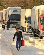 群馬県安中市と長野県軽井沢町を結ぶ国道１８号線のバイパスでは、１５日未明から車が立ち往生している。ガソリンスタンドで入手した燃料を車両に運ぶドライバー＝１７日午後、長野県軽井沢町（桐原正道撮影）