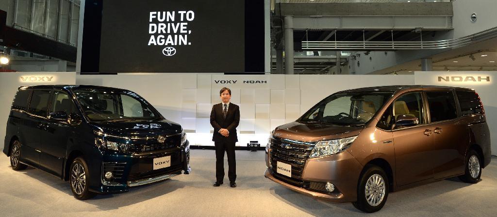 トヨタが発表した新型「ヴォクシー」（左）と新型「ノア」。両車の間に立つ製品企画本部の水澗英紀チーフエンジニア