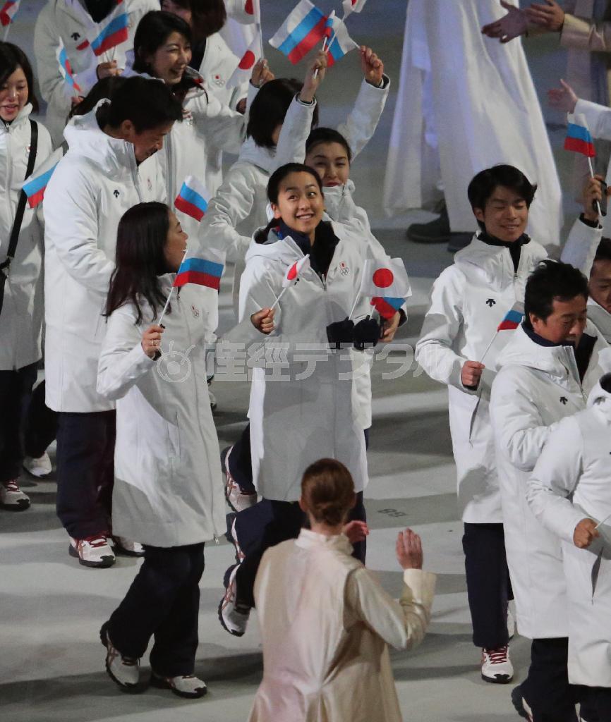 閉会式で日の丸の小旗を手に笑顔で入場する浅田真央（まお）選手（中央）ら日本選手団＝２０１４年２月２３日、ロシア・ソチのフィシュト五輪スタジアム（古厩正樹撮影）