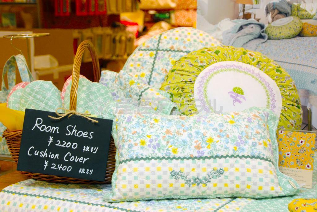 華やかなイラストのクッション（奥から２５２０円、３３６０円、手前の長方形のクッション２３１０円）