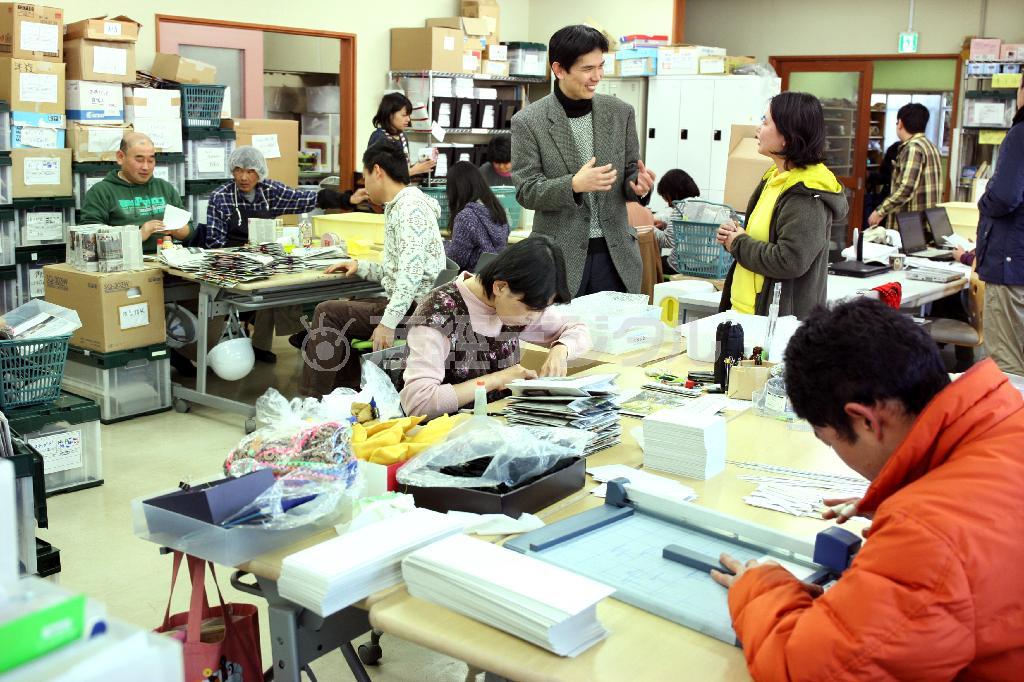 通所施設「地域作業所＿ｈａｎａ（ハナ）」では利用者たちが幾つもの工程に分かれて製作に励む。「こんなに明るく活気に満ちた作業所は初めて」と、作家の天童荒太（てんどう・あらた）さん＝２０１４年２月７日、千葉県木更津市（瀧誠四郎撮影）