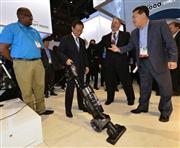 ＣＥＳ会場のサムスン電子ブースで掃除機の説明を受けるパナソニックの津賀一宏社長（左から２人目）＝１月７日、米ラスベガス