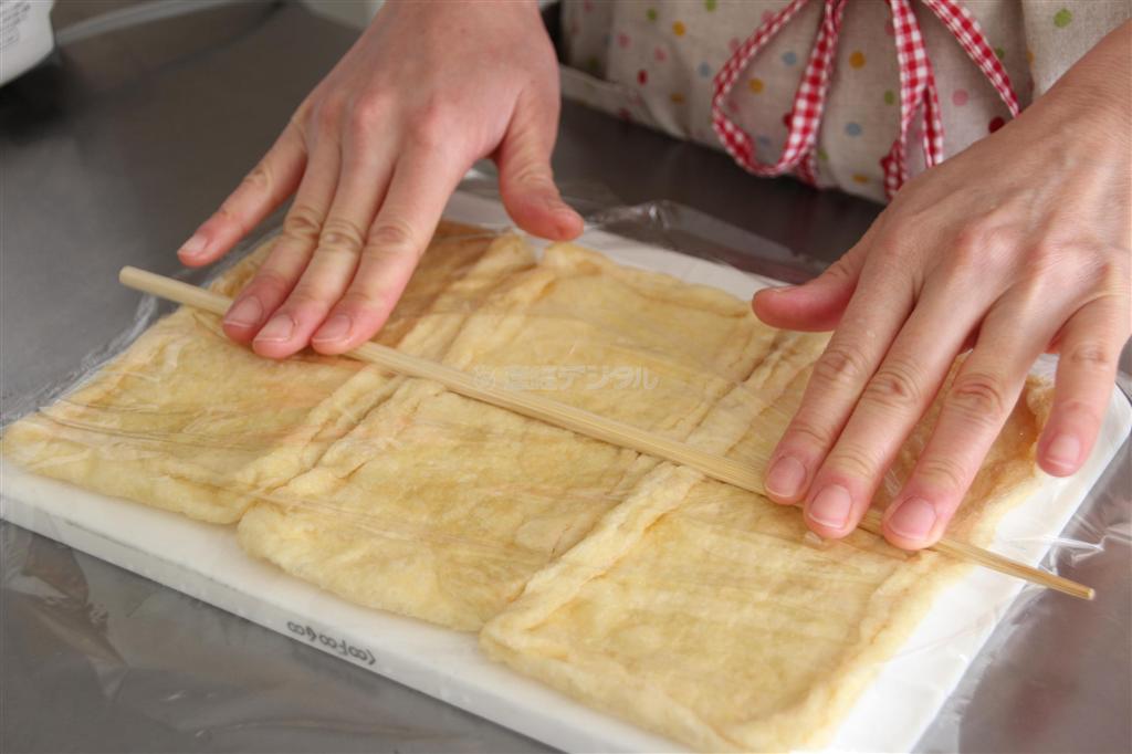 飾りいなりずし（作り方１）＿＿油揚げは菜箸（さいばし）を転がしてならし、半分に切ってたっぷりの熱湯で２分ゆでる。水に取って洗って絞り、袋状にする（今泉有美子撮影）