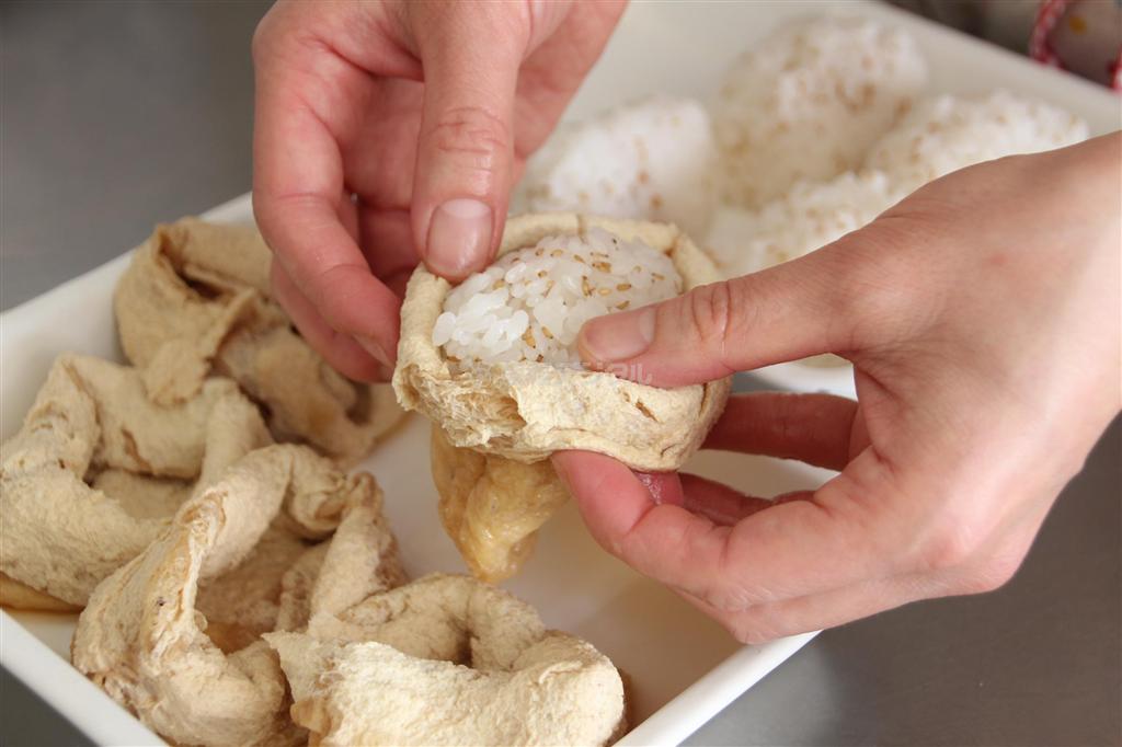飾りいなりずし（作り方４）＿＿調理した「油揚げ（作り方２）」の汁気を切って袋状にし、「俵型にまとめた酢飯（作り方３）」を入れる。油揚げのふちを内側に折り、好みで飾り用の具を乗せる（今泉有美子撮影）