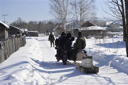 村の若者が共同井戸で汲んだ水をそりに乗せ、サイドカー付きのバイクで引いていった＝２０１１年２月２０日、ロシア・クラスヌィ・ヤール村（伊藤健次さん撮影）