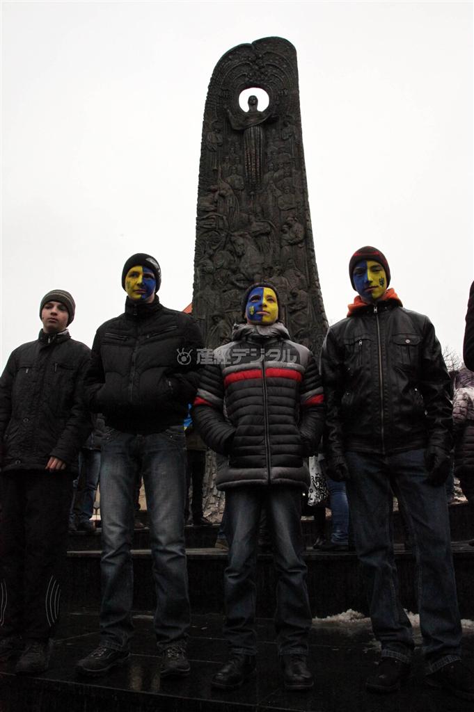 独立広場で記念碑の前に立つ若者たち。黄色と水色はウクライナカラーだ＝２０１３年１２月６日、ウクライナ・リビウ州リビウ（佐々木正明撮影）