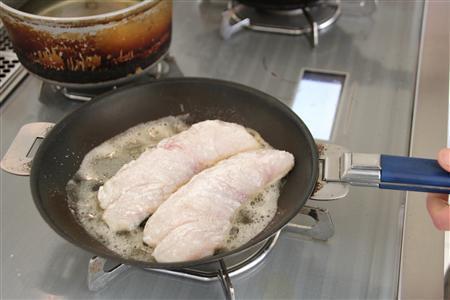 たらのムニエル＿ゆずこしょう風味のタルタルソース添え（作り方１）＿＿たらに塩、こしょうし、小麦粉を薄くまぶし、オリーブ油、バターを熱したフライパンで香ばしくソテーする（今泉有美子撮影）