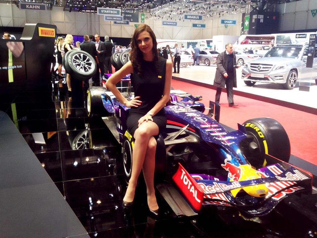 仏タイヤメーカー「ピレリ」のブースのＦ１マシンに腰掛けポーズを決めるモデル＝４日、ジュネーブモーターショー