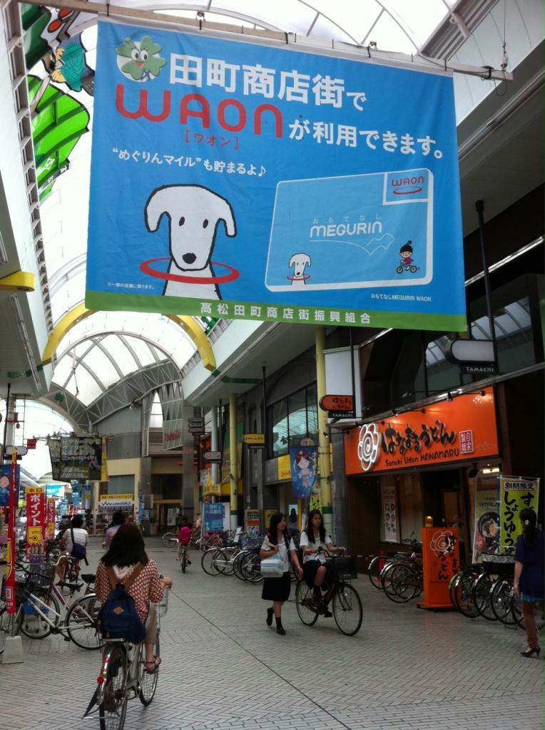 商店街のアーケードで香川県の地域通貨「めぐりん」と一体化した「めぐりんＷＡＯＮ」を知らせる懸垂幕＝高松市（イオン提供）