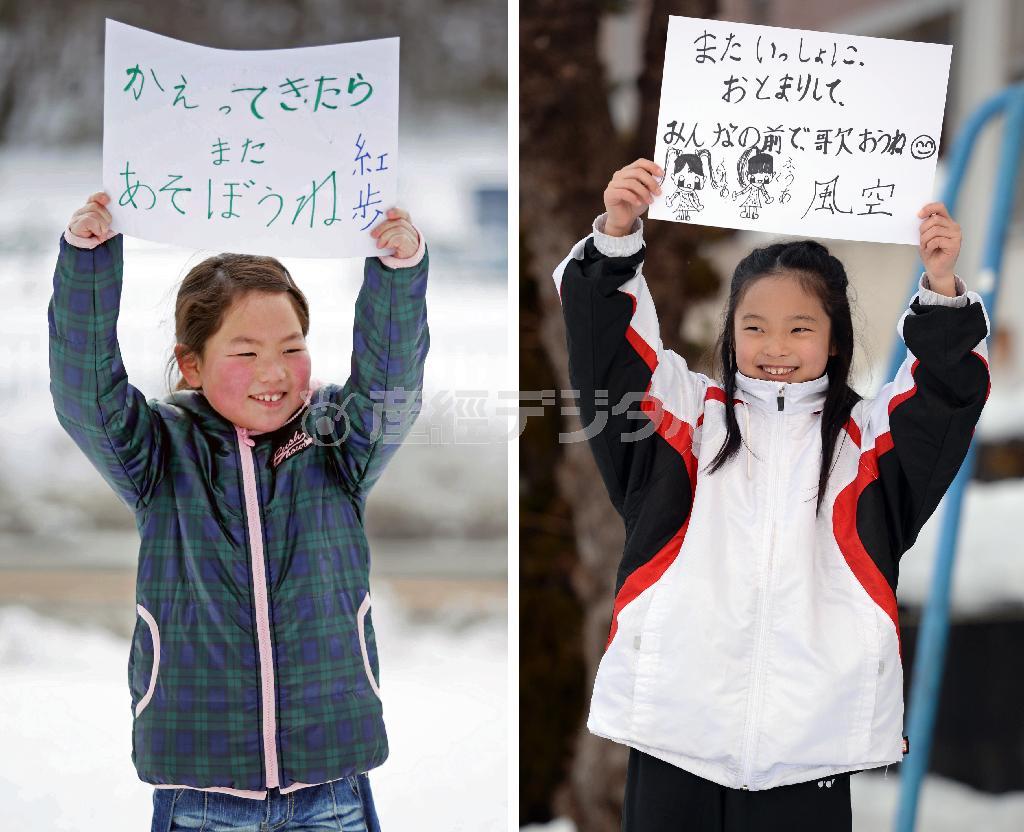 震災後に離ればなれになってしまった安斎紅歩（くれあ）さんと黒沢風空（ふうあ）さん。今では年に数回しか会えないが、一緒に遊べる日に思いをはせながらお互いへのメッセージを元気に掲げた＝２０１４年２月２２日、福島県伊達郡川俣町（左、松本健吾撮影）、山形県山形市（右、鴨川一也撮影）