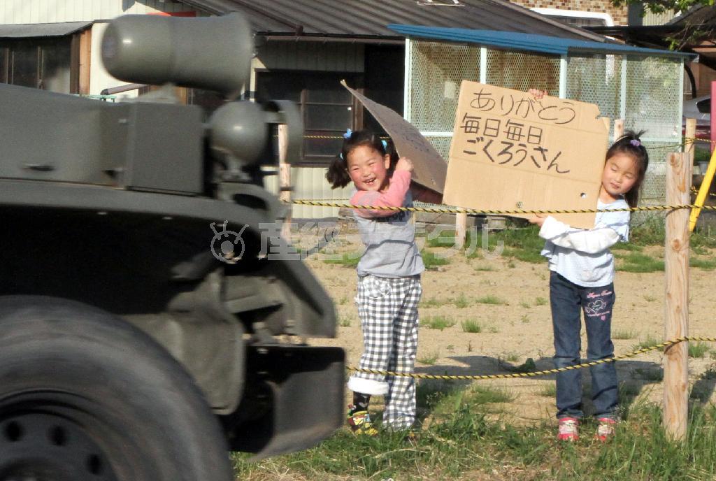 震災当初、自衛隊の復興支援車両が通るたびに仲良く並んで感謝のメッセージを掲げていた安斎紅歩（くれあ）ちゃん（左）と黒沢風空（ふうあ）ちゃん＝２０１１年５月２４日、福島県伊達郡川俣町（大西正純撮影）