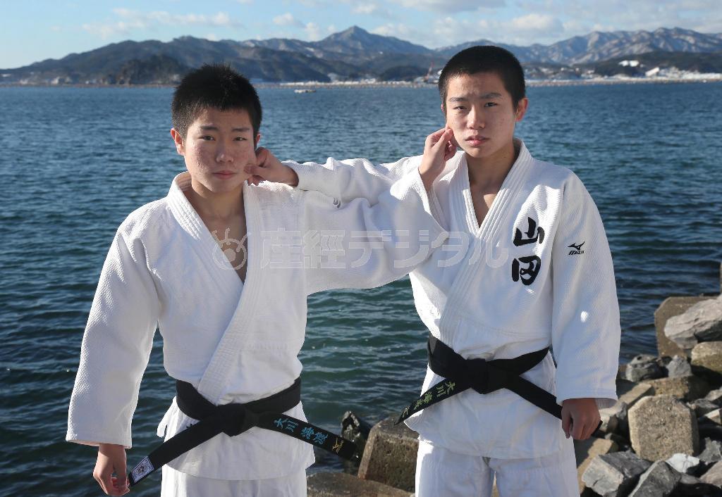 ３年前と同じようにお互いの頬をつねるポーズを取る双子の兄、大川海渡（かいと）君と弟、海成（かいせい）君。４月からは別々の高校へ進み、柔道の県大会では初めて敵味方となって闘うことに＝２０１４年２月１４日、岩手県下閉伊郡山田町（鈴木健児撮影）