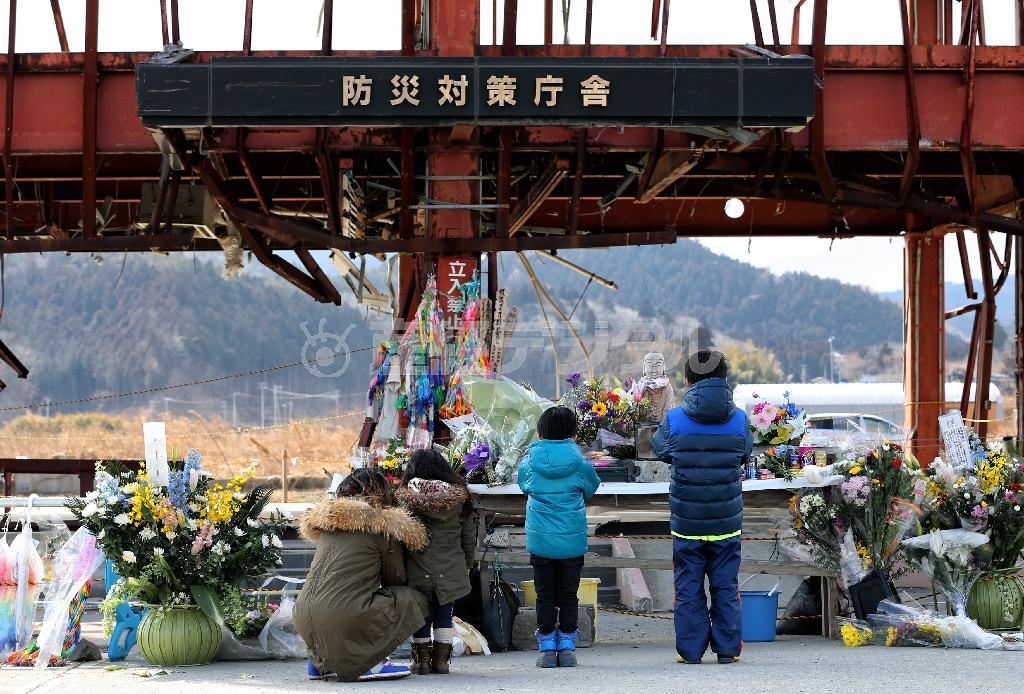 宮城県本吉郡南三陸町の防災対策庁舎前の祭壇で手を合わせる家族連れ。知人の冥福を祈った＝２０１４年３月１１日午後（早坂洋祐撮影）
