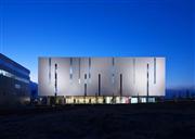 試験管をイメージした外観。施設内には太陽熱や空気熱を利用した給湯や太陽光パネル、ＢＥＭＳ（ビルエネルギー管理システム）など環境負荷を低減する設備を導入。川崎市建築物環境配慮制度（ＣＡＳＢＥＥ川崎）で最高ランクを取得している。（撮影・三輪晃久写真研究所）