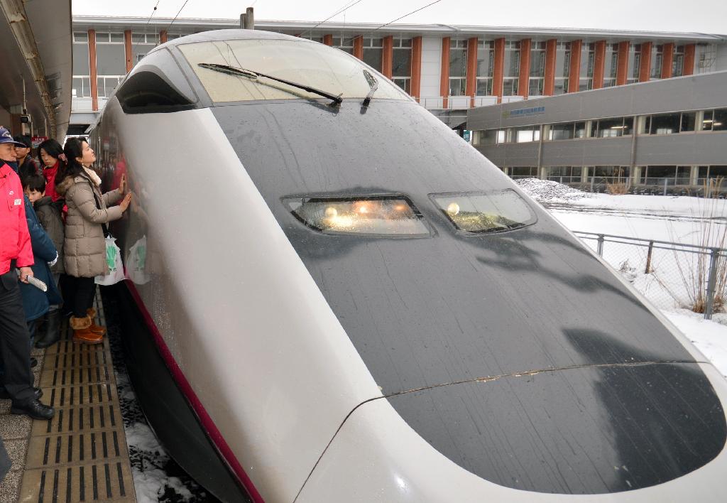 秋田新幹線「Ｅ３系こまち」との別れを惜しんで、車両に触れる女性＝１４日、ＪＲ秋田駅（渡辺浩撮影）