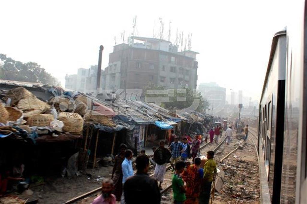 線路沿いに続くスラム。列車すれすれのきわどい場所で、人々がくらしを営んでいる