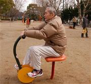 サイクル運動を行う男性。健康遊具は手軽に体力づくりができると人気を集めている＝兵庫県伊丹市の瑞ケ池公園