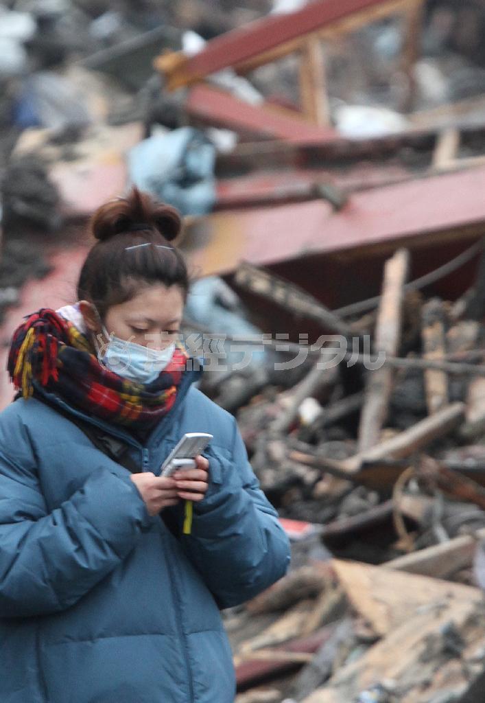 東日本大震災で大きな被害を受けた岩手県上閉伊郡大槌町で、携帯電話を操作する女性。震災直後は携帯の通話もメールもほとんどつながらなった＝２０１１（平成２３）年３月２１日（産経新聞、大西史朗撮影）