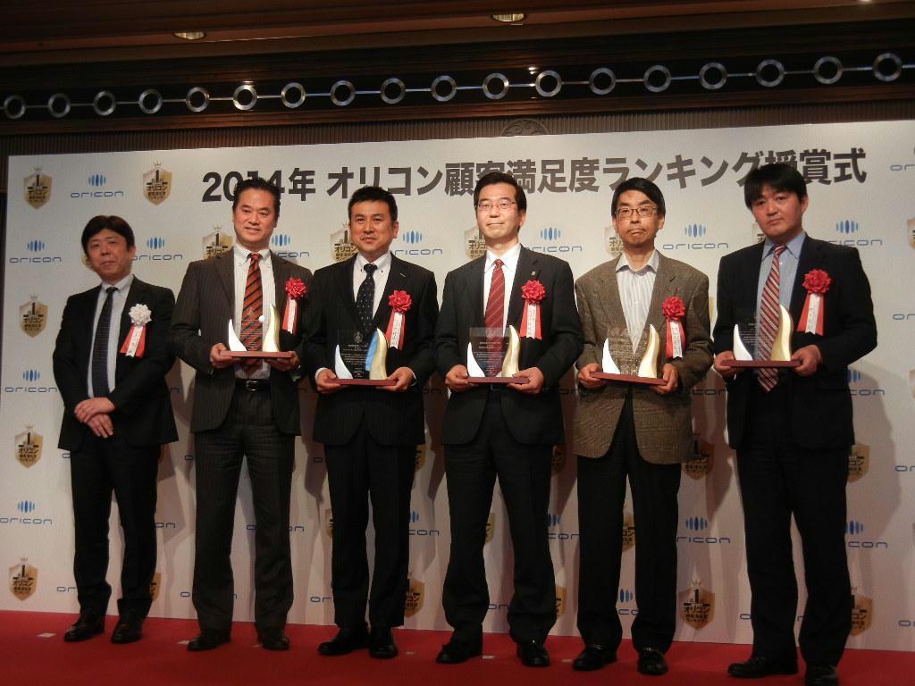 オリコンの小池社長（左）とともに記念撮影に並ぶ保険部門の受賞者ら＝１９日、東京都港区の明治記念館