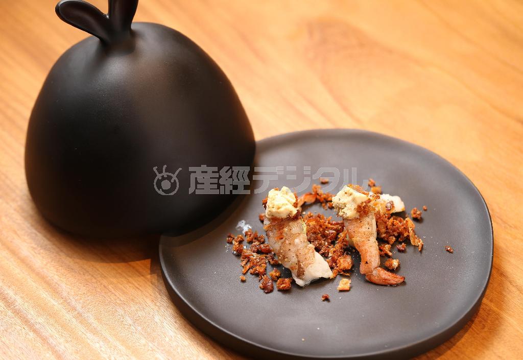 九条ネギと海老、バニラアイスが見事な触感と味わいを生み出す「海老とネギのサラダ」。お皿に敷かれた揚げてクリスピー状にした海老の頭の香ばしさも魅力だ。どの料理もこだわり抜いた食器に乗って登場する