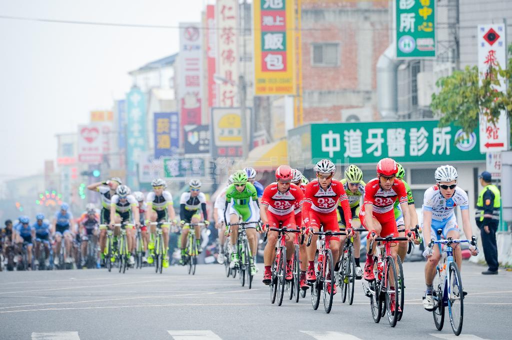 にぎやかな街の看板を横目に走り抜ける選手たち。開催期間中、天気は曇りや霧が多かった＝２０１４年３月、台湾（田中苑子さん撮影）