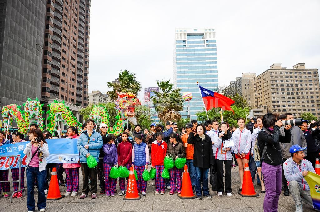 スタート地点に応援に駆け付けた地元の小学生ら。春の台湾とはいえ、風が吹くとまだ寒い＝２０１４年３月、台湾（田中苑子さん撮影）