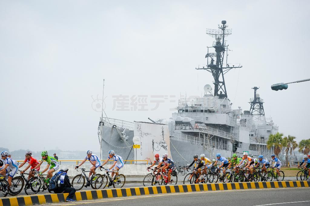 台湾の海を守ってきた駆逐艦「徳陽」の前を通過する選手たち＝２０１４年３月、台湾・台南市（田中苑子さん撮影）