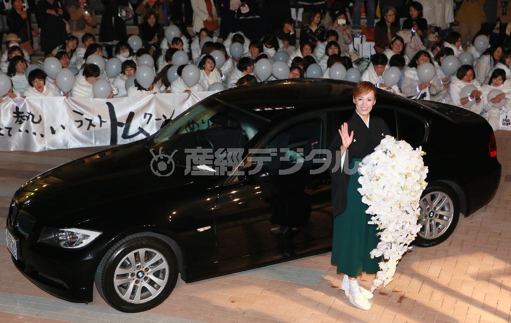 宝塚大劇場前でのサヨナラ・パレードで、大きな蘭の花束を手にファンに手を振る蘭寿とむ＝２０１４年３月１７日午後、兵庫県宝塚市（松永渉平撮影）