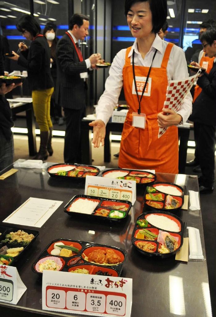 消費税増税に合わせ、高齢者向けの配食サービスに投入する低価格商品を披露したワタミタクショクの発表会場