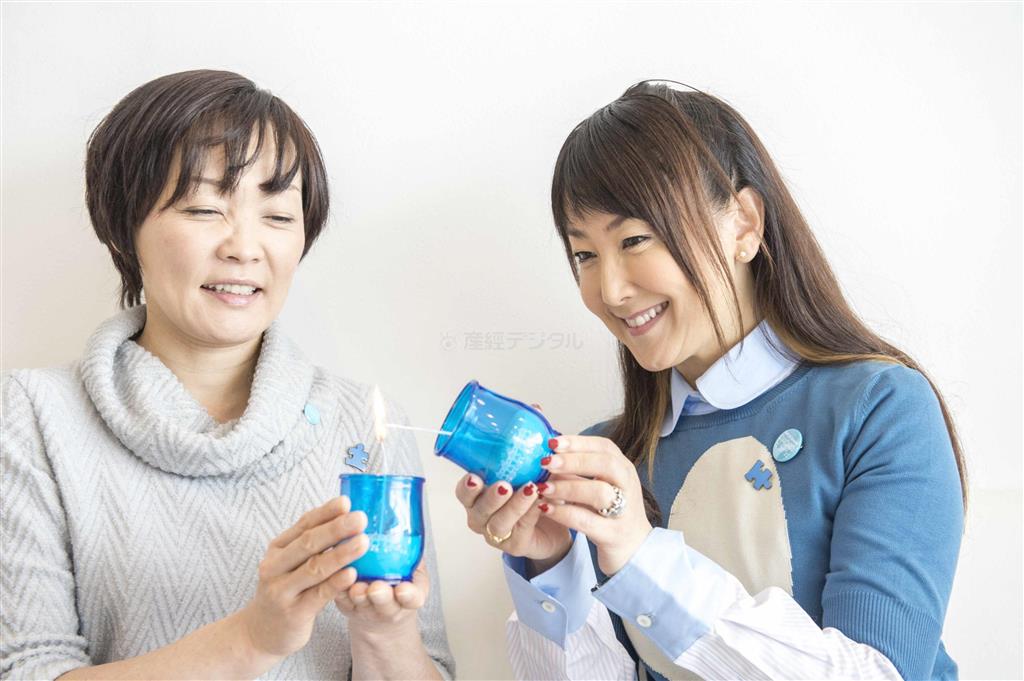 世界自閉症啓発デーのシンボルでもある「青色」のろうそくをともす安倍昭恵さん（左）と東ちづるさん（山下元気さん撮影、提供写真）