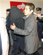 移送される杉田吉隆容疑者（左）＝１３日夜、東京・羽田空港