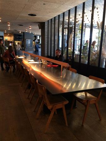 長いテーブルが置かれたエースホテルのロビー。流行に敏感な若者が集う情報発信地にもなっている＝２０１４年３月９日、英国・首都ロンドン（関本美弥子さん撮影）