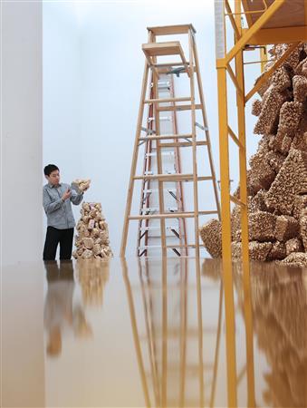 コム・デ・ギャルソン＿チェルシー店の改装作業の最中、ツリーの突端の最終調整を行う名和（なわ）晃平さん＝２０１３年１２月１７日、米ニューヨークのチェルシー地区（中尾由里子さん撮影）