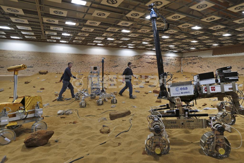 ２０１８年に打ち上げられる火星無人探査車の実験場「マーズヤード」を歩く欧州宇宙機関（ＥＳＡ）の職員たち。火星に似せた赤茶けた土壌が広がるさまはまるで巨大な砂場だ…＝２０１４年３月２７日、英国・首都ロンドン郊外スティーブニッジ（ＡＰ）