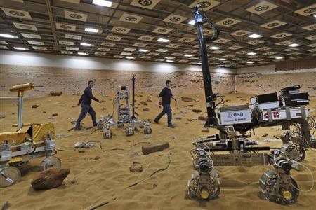 ２０１８年に打ち上げられる火星無人探査車の実験場「マーズヤード」を歩く欧州宇宙機関（ＥＳＡ）の職員たち。火星に似せた赤茶けた土壌が広がるさまはまるで巨大な砂場だ…＝２０１４年３月２７日、英国・首都ロンドン郊外スティーブニッジ（ＡＰ）