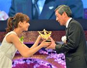 フジサンケイグループ広告大賞贈賞式大賞を受賞し、プレゼンターの西内まりやさんからトロフィーをもらうパナソニック株式会社の長榮周作・代表取締役会長（右）＝８日午後、東京都港区（三尾郁恵撮影）