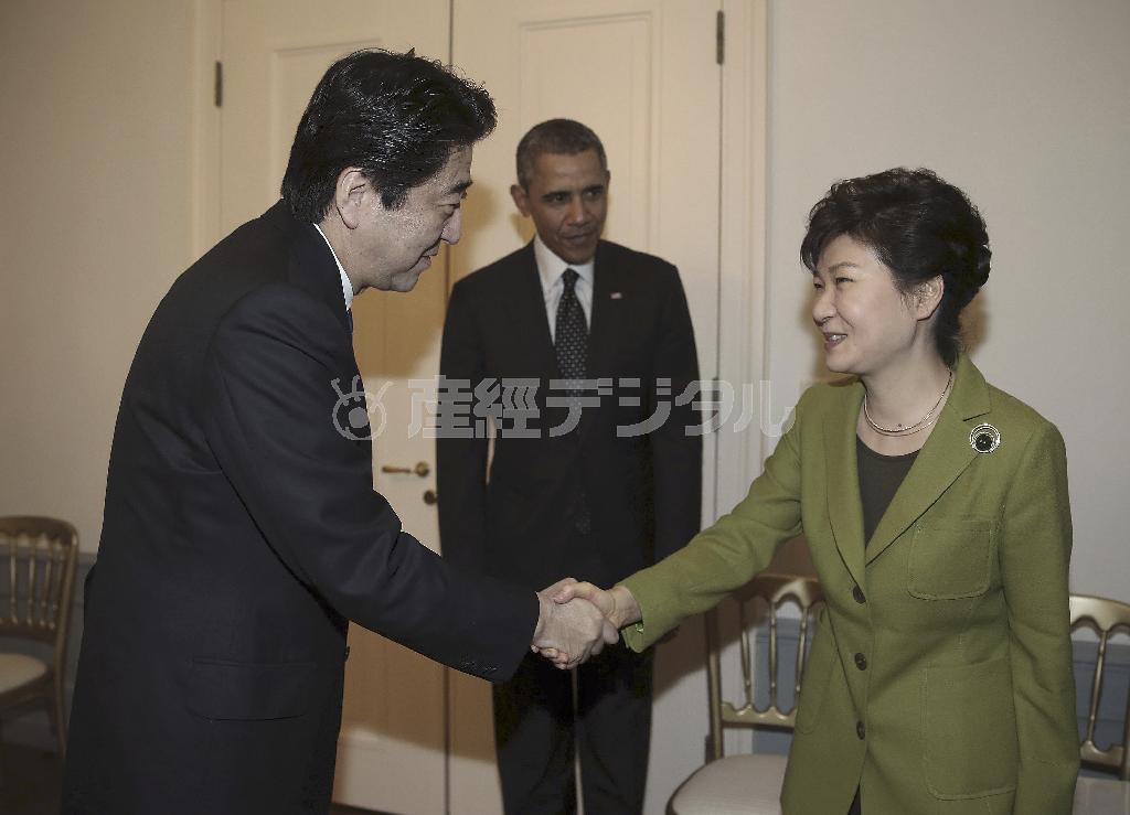 日米韓３カ国首脳会談を前に、安倍晋三（しんぞう）首相と握手する韓国の朴槿恵（パク・クネ）大統領（右）。中央はバラク・オバマ米大統領。この握手が日韓関係の改善につながるかは不透明だ＝２０１４年３月２５日、オランダ・ハーグ（ＡＰ）