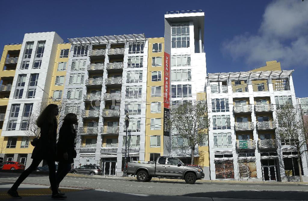 米カリフォルニア州サンフランシスコで、アパートやマンションが軒を連ねる通りを歩く女性。家賃高騰によって、高額所得者以外が“霧の都”に住むには、シェアかウサギ小屋しかなくなりつつある＝２０１４年３月１７日（ＡＰ）