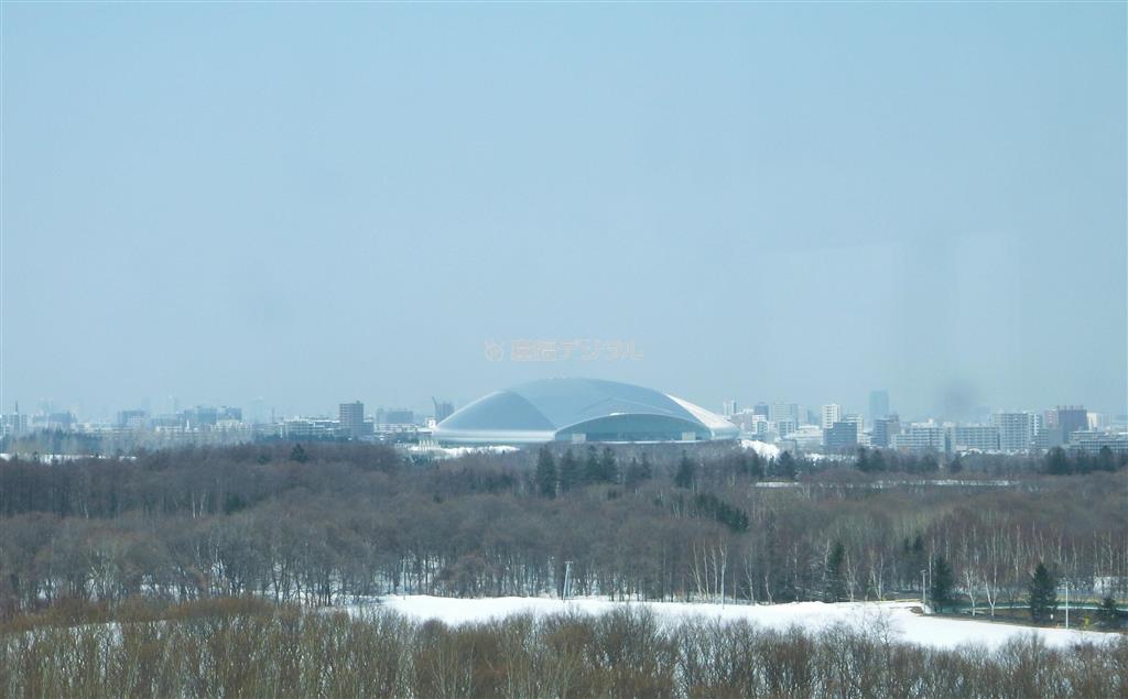 某所からながめた札幌ドーム。北の町にはまだ雪が残っています＝２０１４年３月２６日、北海道札幌市（乾ルカさん撮影）