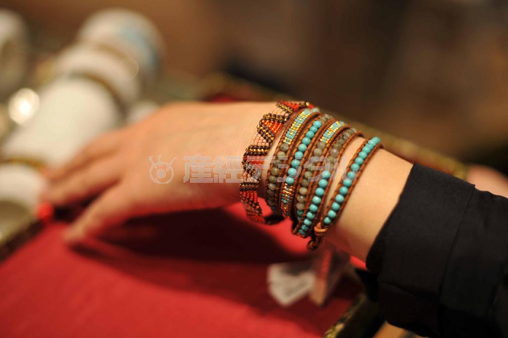ネーティブ・アメリカンの文化をヒントにしたラップブレスレット（青色系、２万３０００＋税円）を５連に巻き、単連のブレスレット（１万２６００円＋税）とおしゃれに重ねづけ＝２０１４年４月５日、東京都千代田区・大丸東京店（原田史郎撮影）