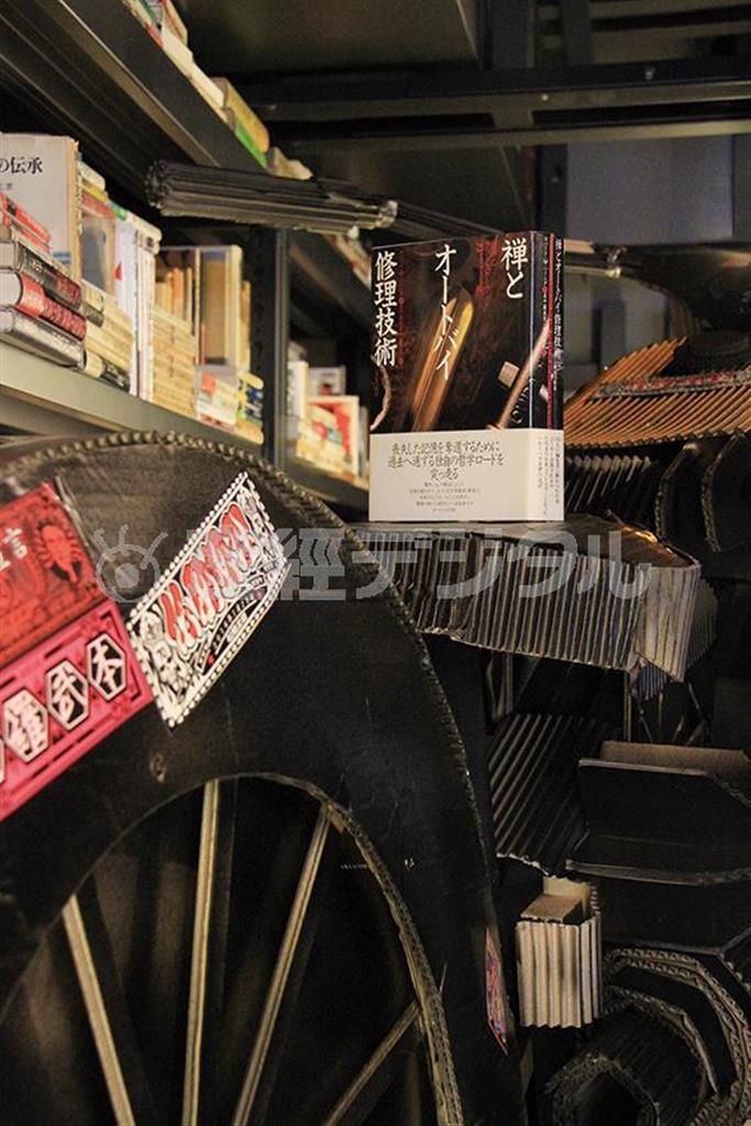 この写真はぼくの古希の祝宴のときに藤本晴美チームが贈ってくれた段ボール・オートバイと、パーシングの『禅とオートバイ修理技術』の取り合わせ。段ボールをみごとに単車に仕立てたのは外山貴洋君（小森康仁さん撮影、松岡正剛事務所提供）