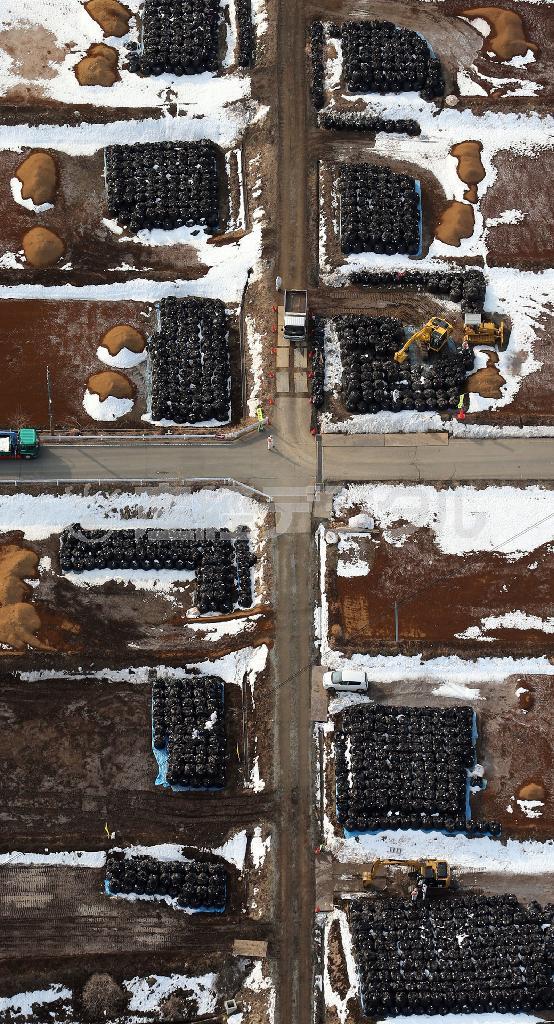 大熊町では除線作業で出た廃棄物を道路沿いに並べる作業が続いていた＝２０１４年２月２０日、福島県双葉郡大熊町（本社チャーターヘリから、鈴木健児撮影）