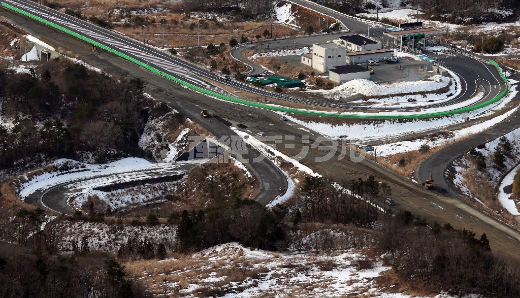 安倍晋三（しんぞう）首相が３月１０日の会見で２０１５年の大型連休までに全線開通させる意向を表明した常磐自動車道。広野インターチェンジ（ＩＣ）から富岡ＩＣまで延伸したが、その先は工事が続く。写真上は完成した富岡ＩＣ、下は工事中の大熊町へと向かう道路＝２０１４年２月２０日、福島県双葉郡富岡町（本社チャーターヘリから、鈴木健児撮影）